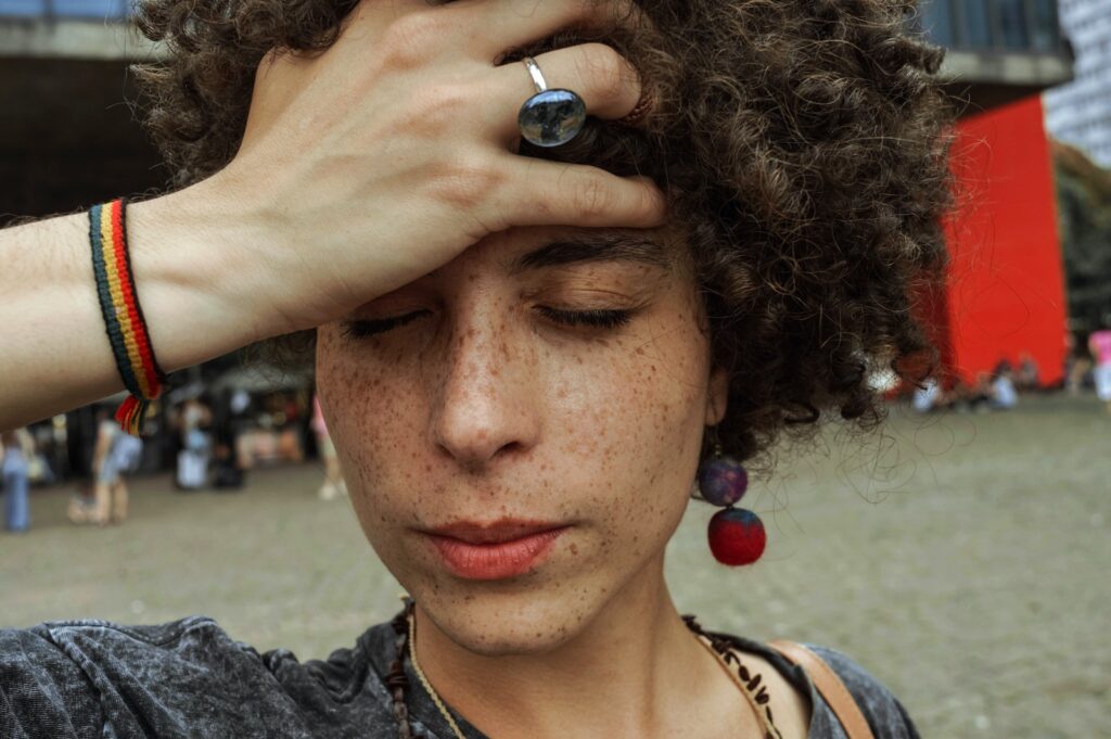 Close-up Photo of Woman with Her Eyes Closed Holding Her Forehead