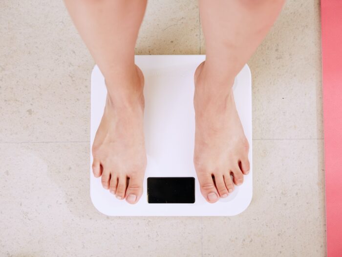 person standing on white digital bathroom scale