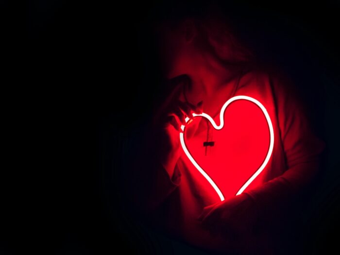 a heart shaped neon sign in the dark