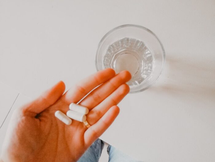 person holding white medication pill