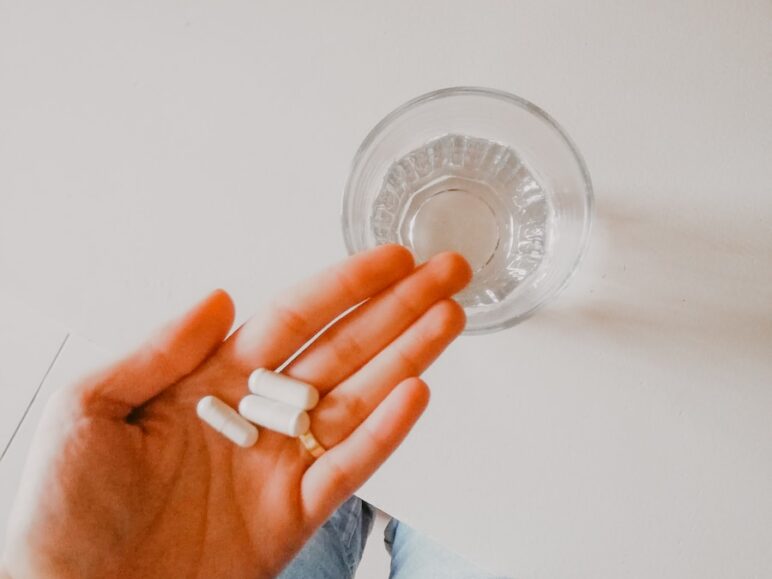 person holding white medication pill