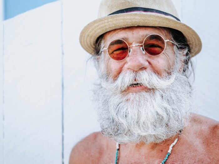 a man with a white beard and mustache wearing a hat