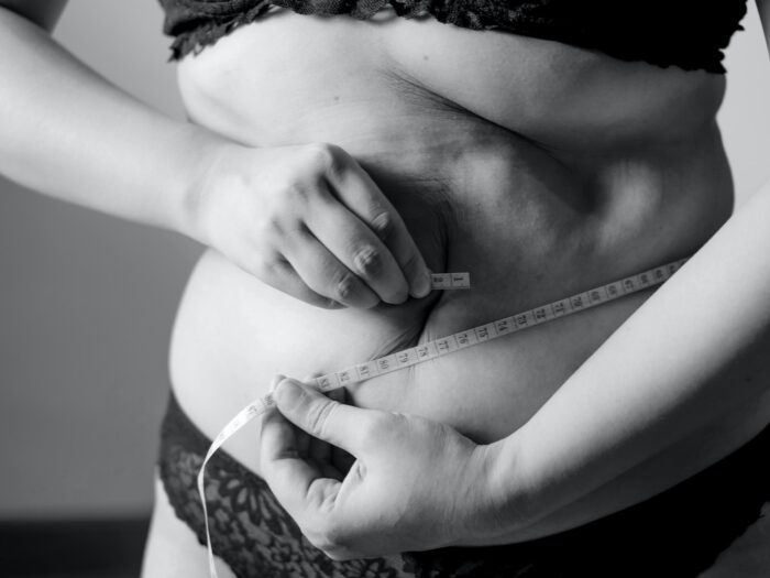 grayscale photo of woman holding her breast