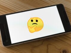 black flat screen tv turned on displaying yellow emoji